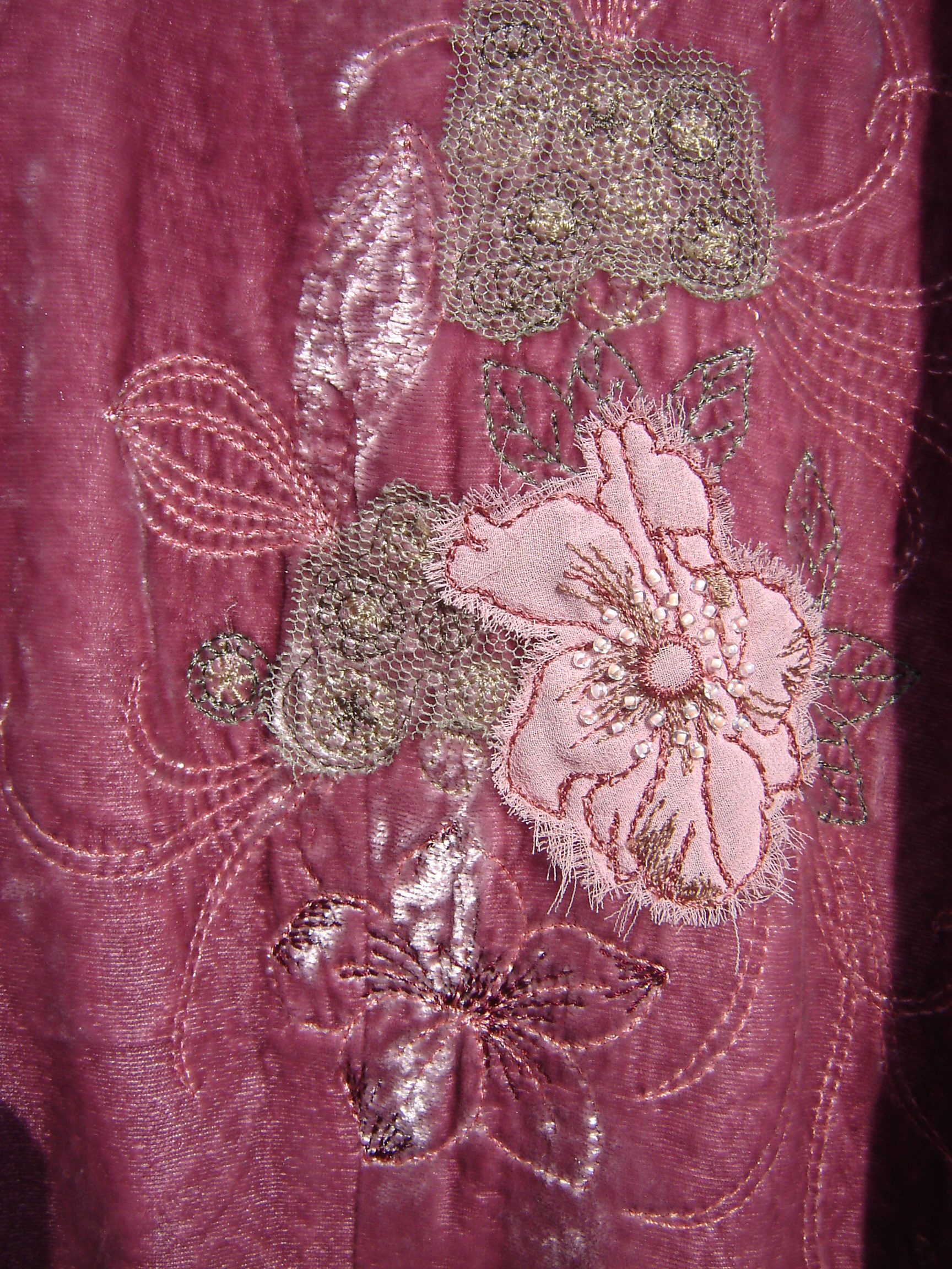 Pink cropped velvet jacket with appliqued flowers.