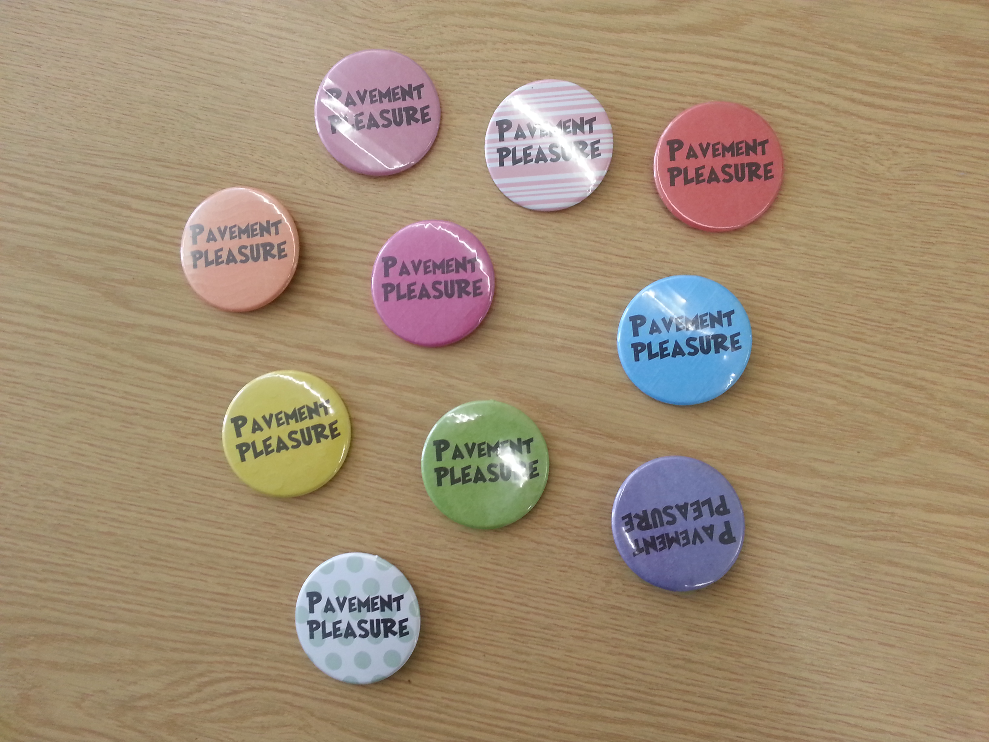 Badges with the words 'Pavement Pleasure' on.